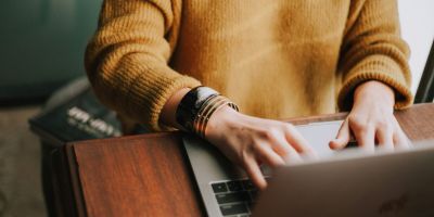 Person typing on a laptop at a desk.